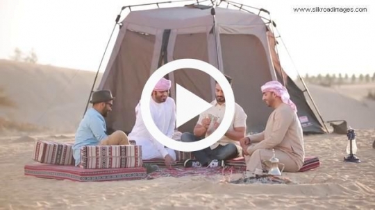 Friends playing cards in desert camp