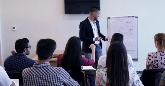 Professor teaching and a student raises her hand |-