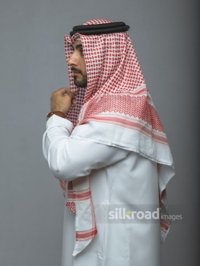 Middle Eastern man fixing traditional attire