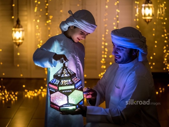 Father holding lantern with son|-