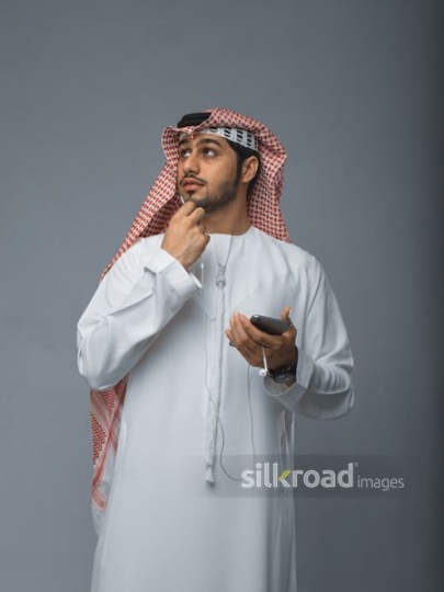 Middle Eastern man talking on the phone using earphones |