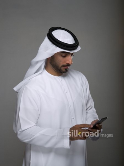 Middle Eastern man texting on the phone|