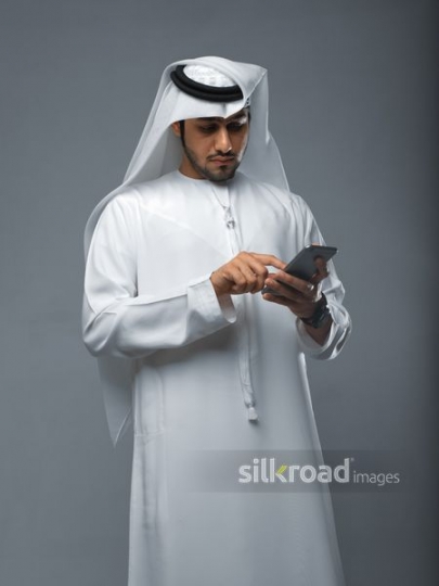 Arab Businessman texting on his phone|