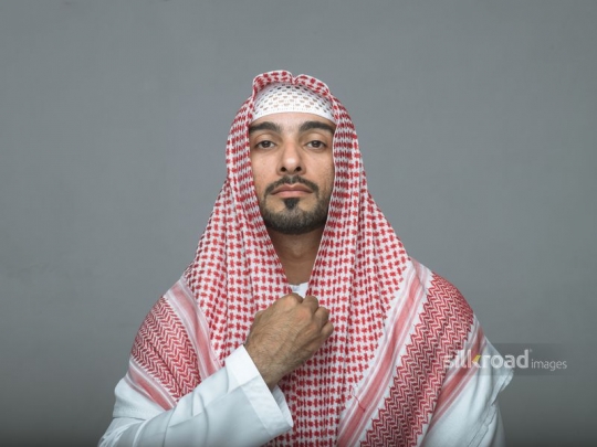 Arab man fixing his attire 