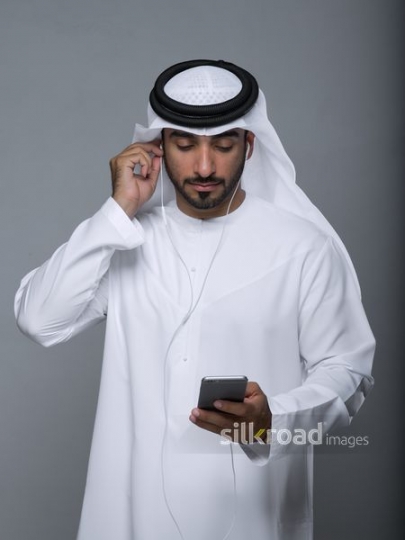 Middle Eastern man adjusting ear phones|