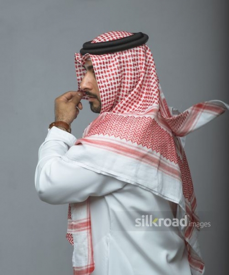 Middle Eastern man fixing his traditional attire