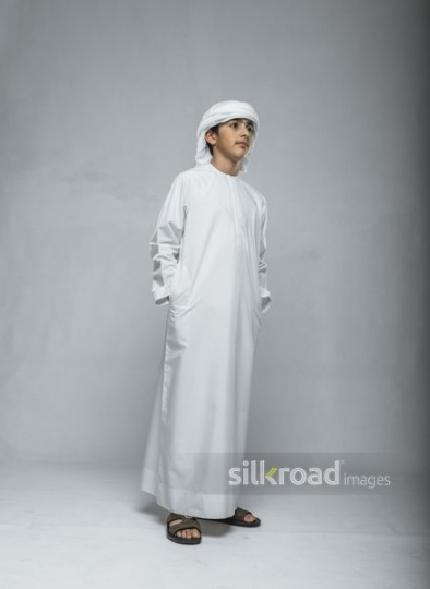 Young boy dressed in the traditional attire standing