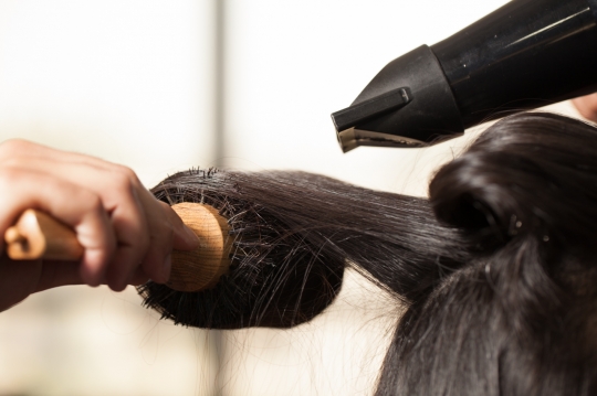 Close up of the woman's hair getting a blow dry|
