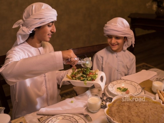 Boy serving brother oriental salad|-
