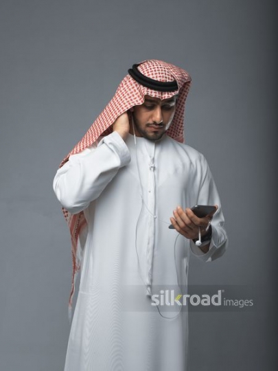 Arab man wearing earphone using his mobile