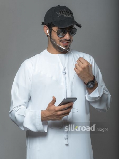 Middle Eastern man wearing a cap talking on the phone|