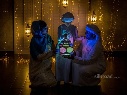Parents with kid holding lantern|-