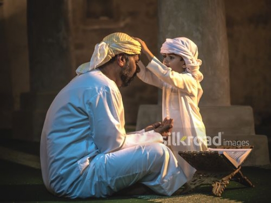 Boy fixing outfit of grandfather|-