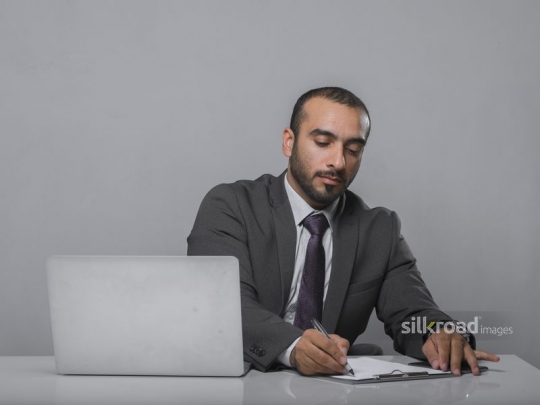Businessman writing on documents