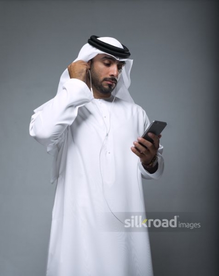 Middle Eastern Businessman fixing his earphones|