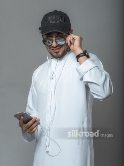 Middle Eastern man wearing a cap using his mobile