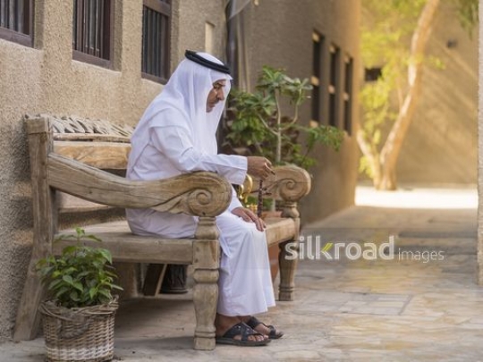 Arab man sitting on the bench with a misbahah in his hand|-