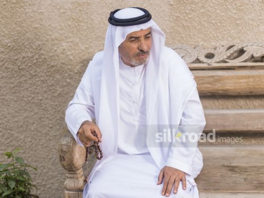 Arab man sitting on the bench with his misbaha|-