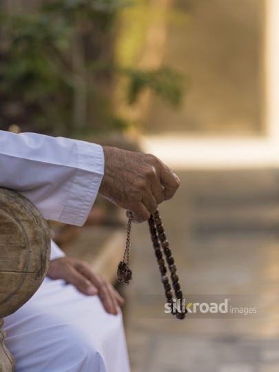 Close up of a misbaha in a mans hand|-