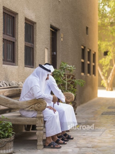 Arab men sitting on the bench together|-