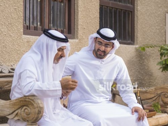 Arab son sitting with his father|-
