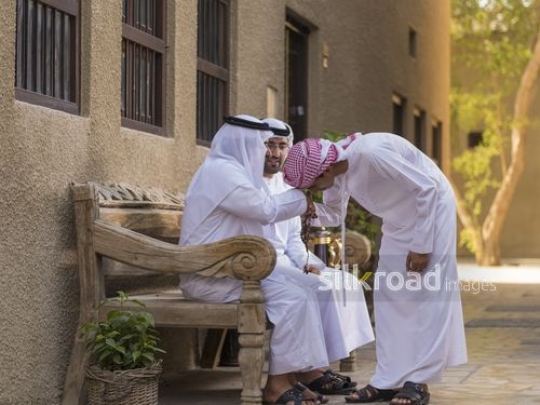 Arab son showing respect to his grandfather|-