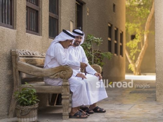Arab grandfather and father sitting together|-
