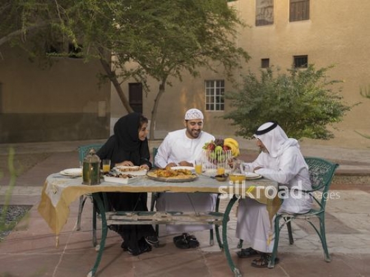 REPLACE - Middle Eastern family sitting together to have iftar|