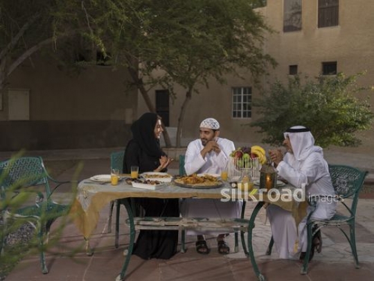 REPLACE - Arab woman talking to both men on the table|-