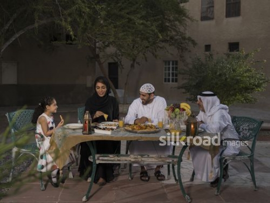 REPLACE - Middle Eastern family sitting together having Iftar|-