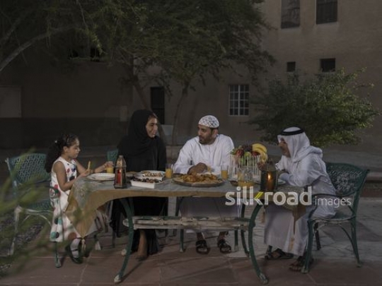 REPLACE - Middle Eastern family sitting together having Iftar|-