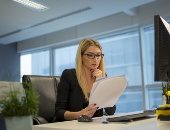 Business woman sitting by her desk concentration on the paper|