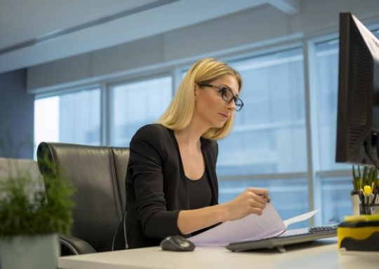 Business woman sitting by her desk working |