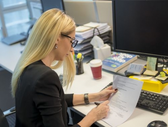 Western woman at the office working by her desk|