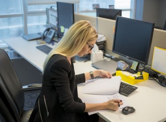 Western woman sitting by her desk working|