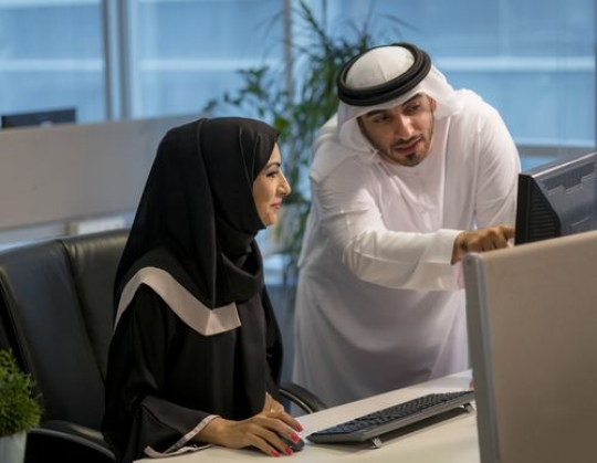 Arab businessman and woman working together|