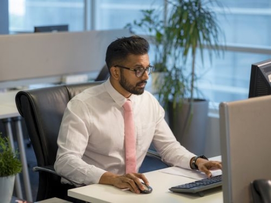 Expat businessman at the office sitting by desk|