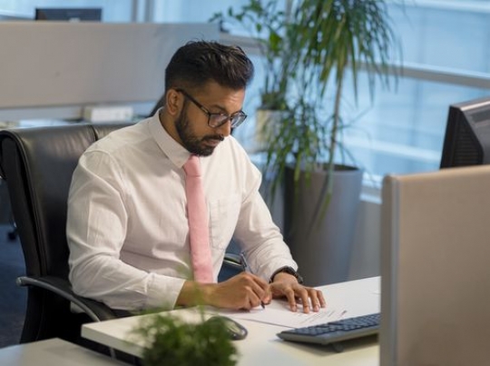 Expat business man sitting by his desk|