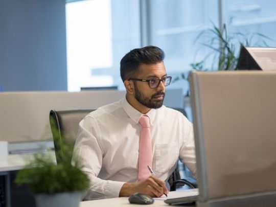 Business man sitting by his desk working|