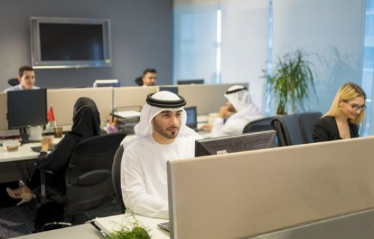 Business man and woman sitting by their desk |