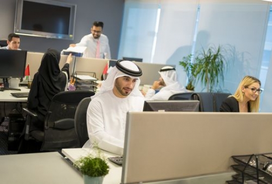 Business man and woman sitting by their desk working|