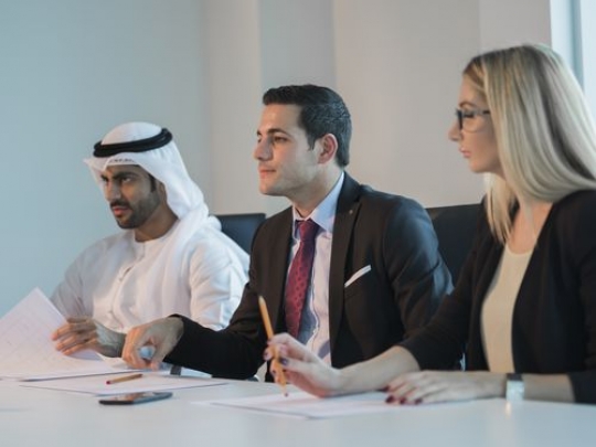 Arab employees and a western employee during a meeting|-