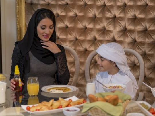 Arab mother and son having breakfast