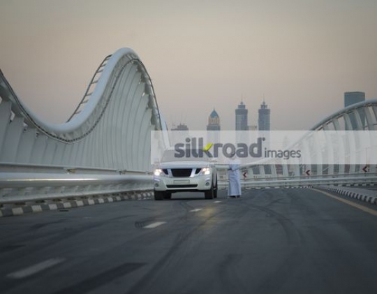 Middle Eastern man dressed in the attire talking on the phone|