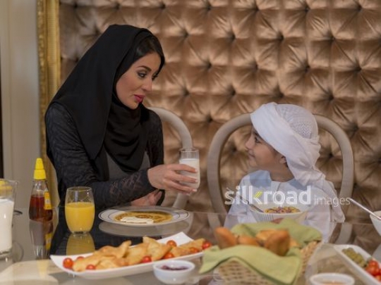 Arab woman telling the boy to drink milk|