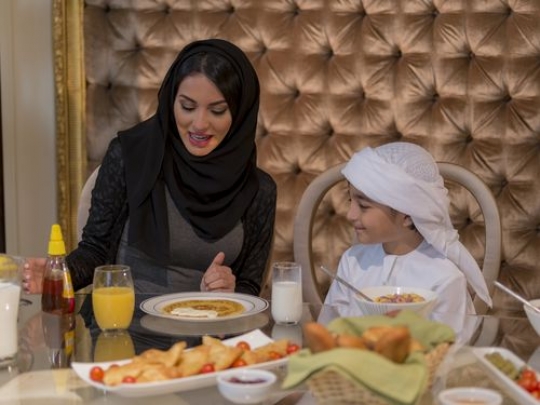 Middle eastern mother having breakfast with her son|-