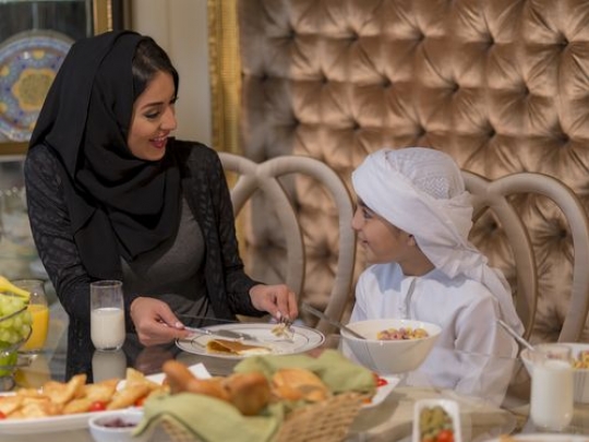 Arab mother and her son sitting talking to each other|-