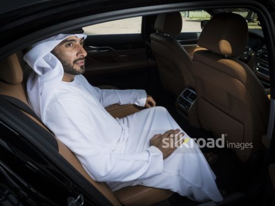 Middle Eastern businessman sitting inside the car|-
