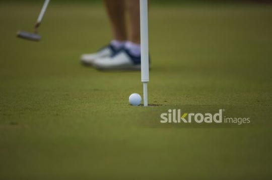 A man is playing golf and scored the shot|-