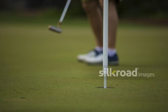 Man playing golf|-